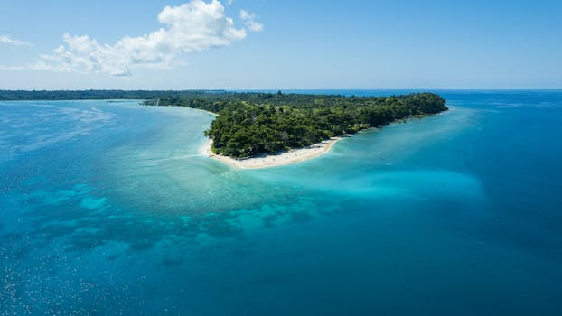 tropical-island, aerial-view, blue-ocean, sandy-beach, lush-vegetation, clear-water, travel-destination